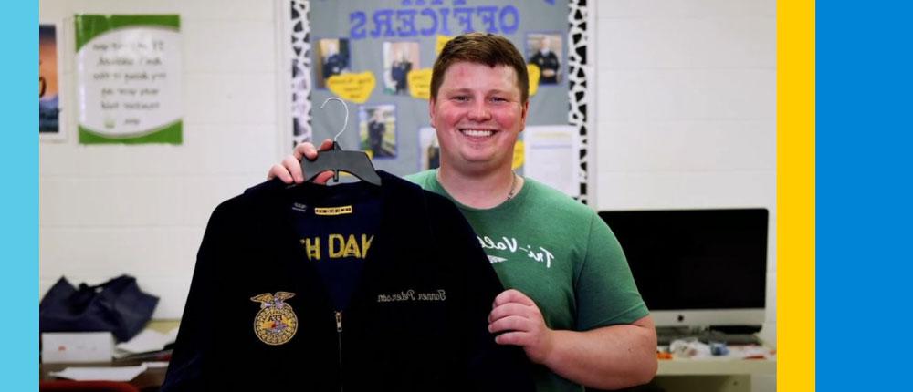 Tanner Peterson holds up the FFA jacket he earned when he was a student